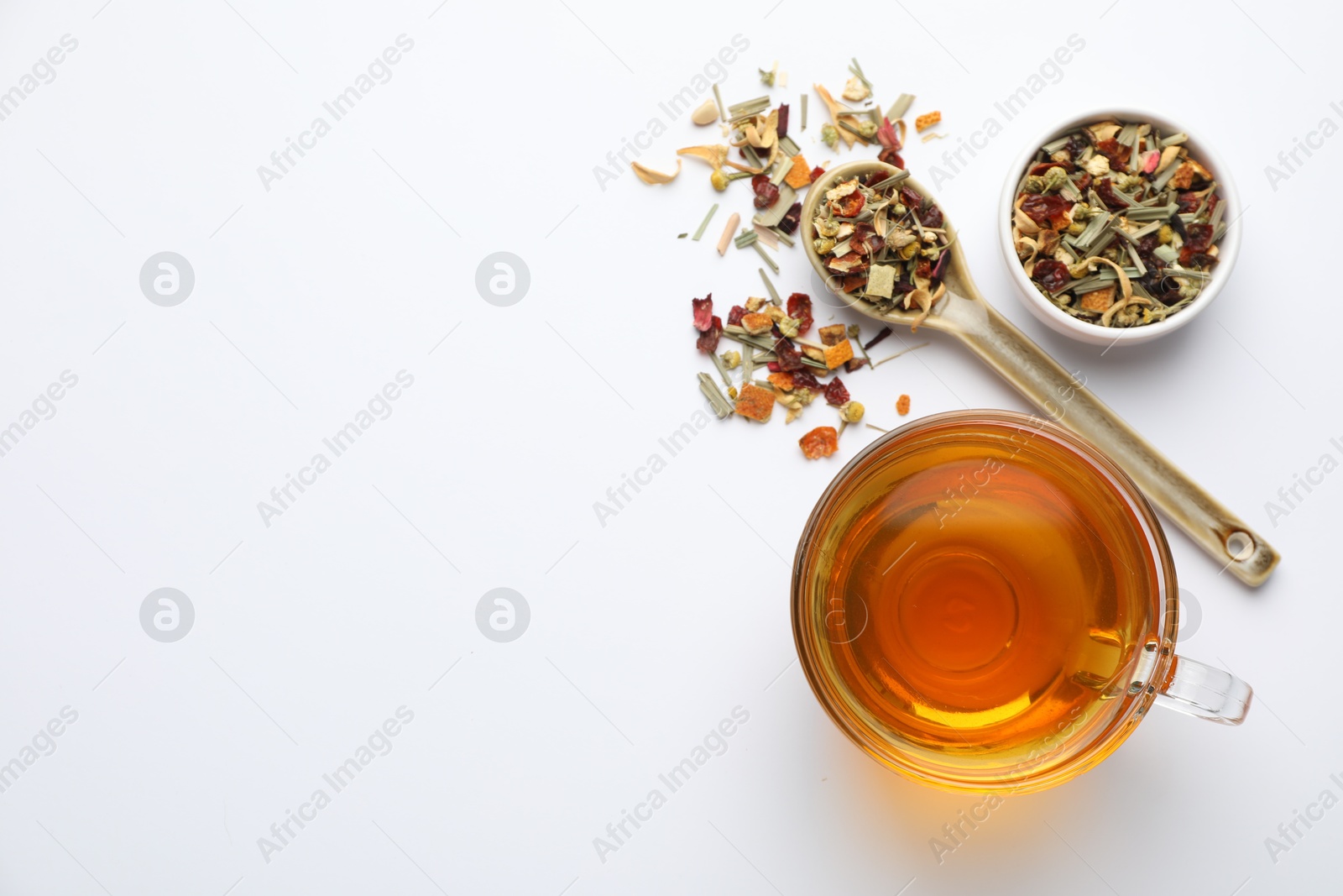 Delicious herbal tea and dry leaves on white background, top view. Space for text Photo of Delicious herbal tea and dry leaves on white background, top view. Space for text