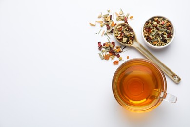Photo of Delicious herbal tea and dry leaves on white background, top view. Space for text