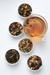 Photo of Delicious herbal tea and different brews on white background, flat lay