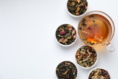 Photo of Delicious herbal tea and different brews on white background, flat lay. Space for text