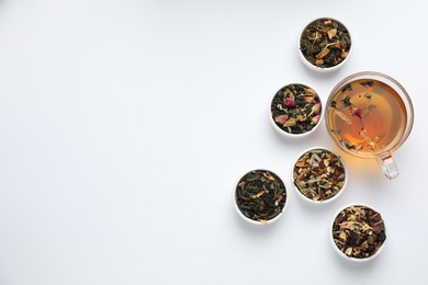 Photo of Delicious herbal tea and different brews on white background, flat lay. Space for text