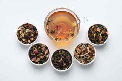 Photo of Delicious herbal tea and different brews on white background, flat lay