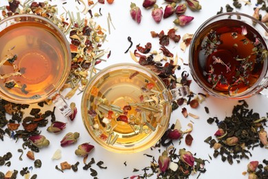 Photo of Different herbal teas and dry leaves on white background, flat lay