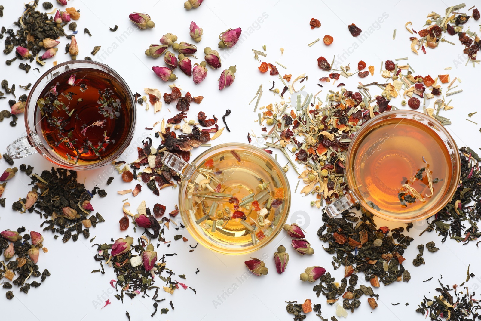 Different herbal teas and dry leaves on white background, flat lay Photo of Different herbal teas and dry leaves on white background, flat lay