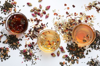 Photo of Different herbal teas and dry leaves on white background, flat lay