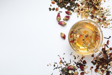 Photo of Delicious herbal tea and different brews on white background, flat lay. Space for text