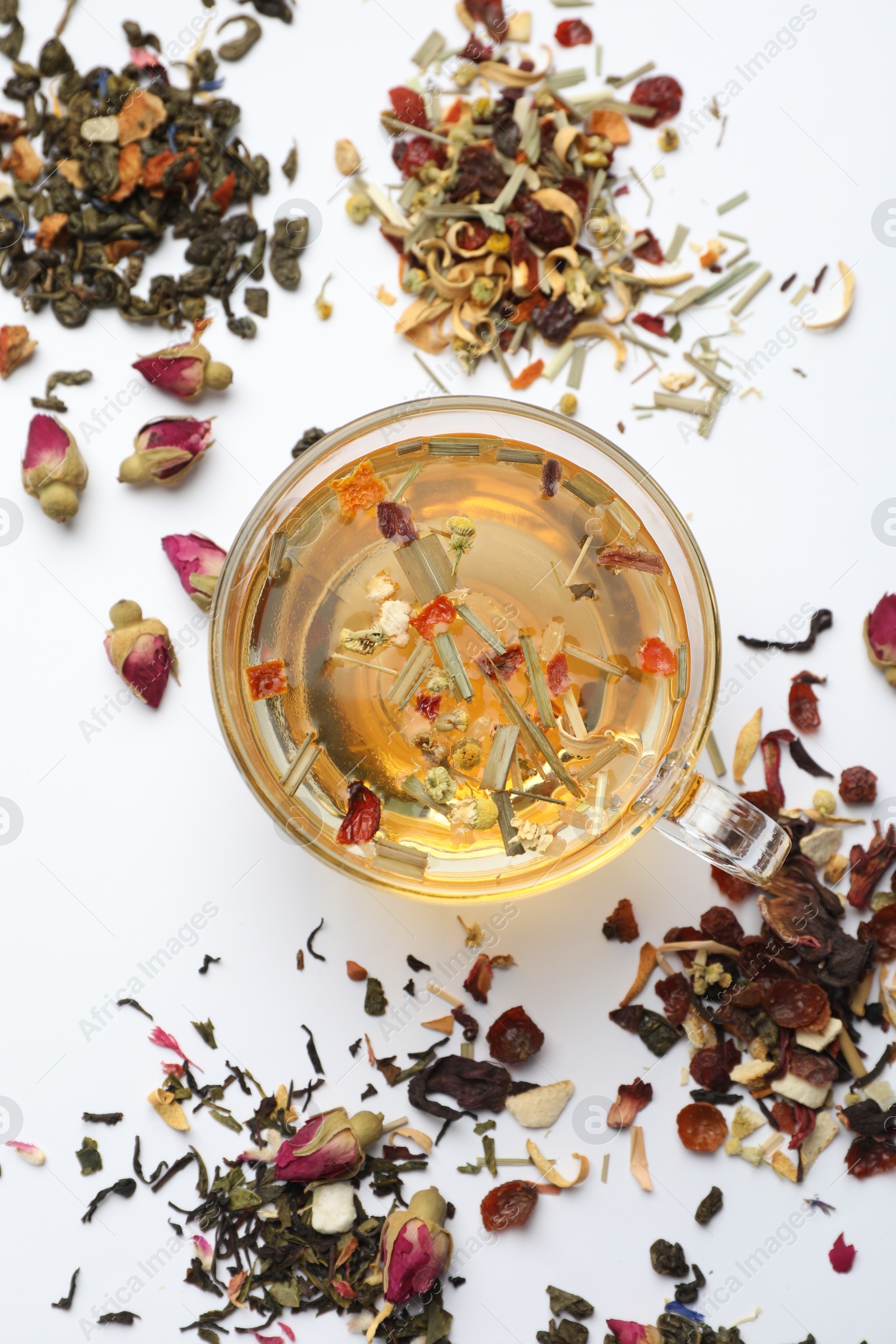 Delicious herbal tea and different brews on white background, flat lay Photo of Delicious herbal tea and different brews on white background, flat lay
