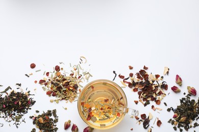 Photo of Delicious herbal tea and different brews on white background, flat lay. Space for text