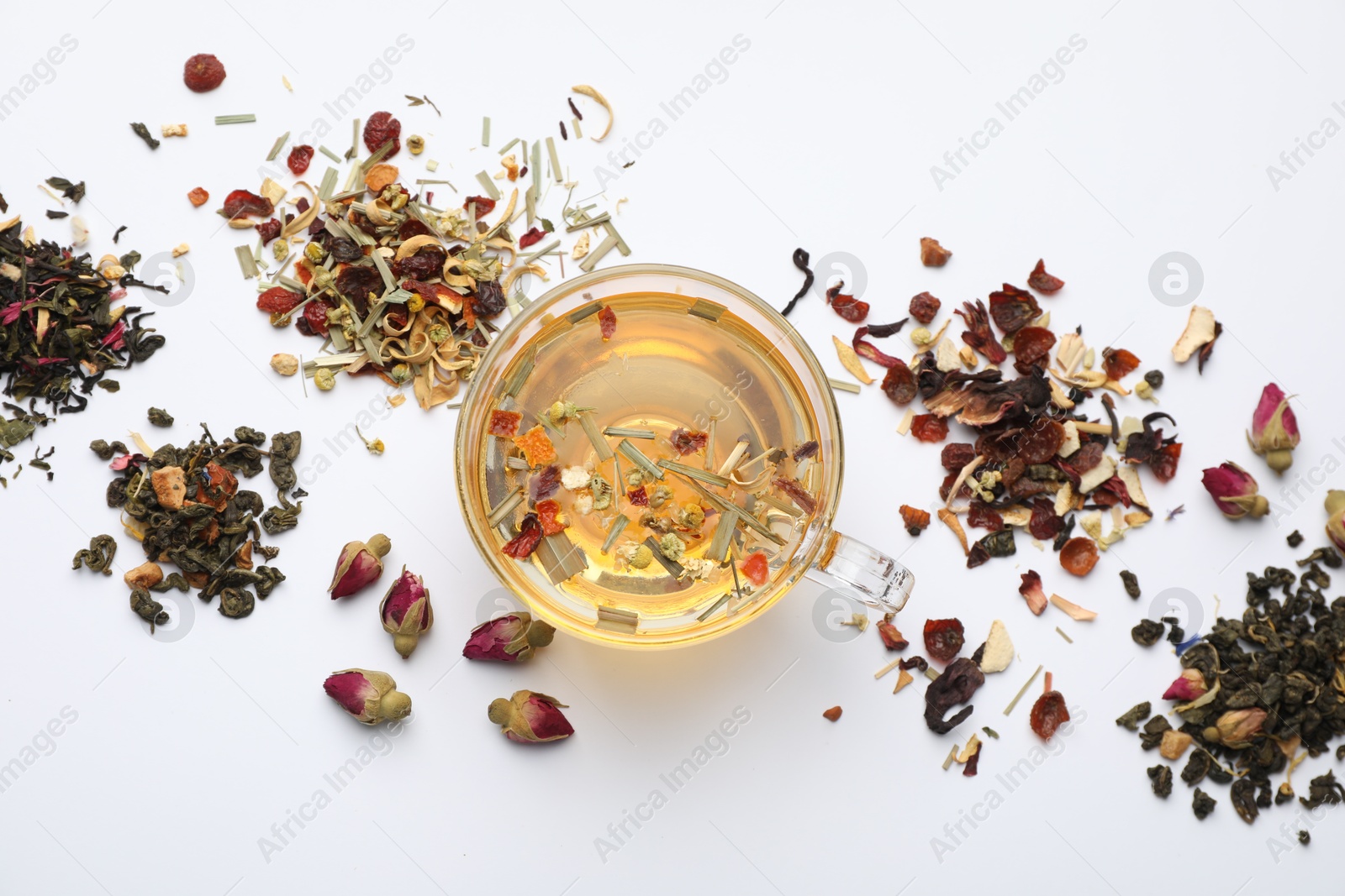 Delicious herbal tea and different brews on white background, flat lay Photo of Delicious herbal tea and different brews on white background, flat lay