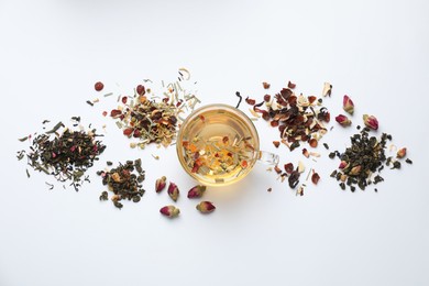 Photo of Delicious herbal tea and different brews on white background, flat lay