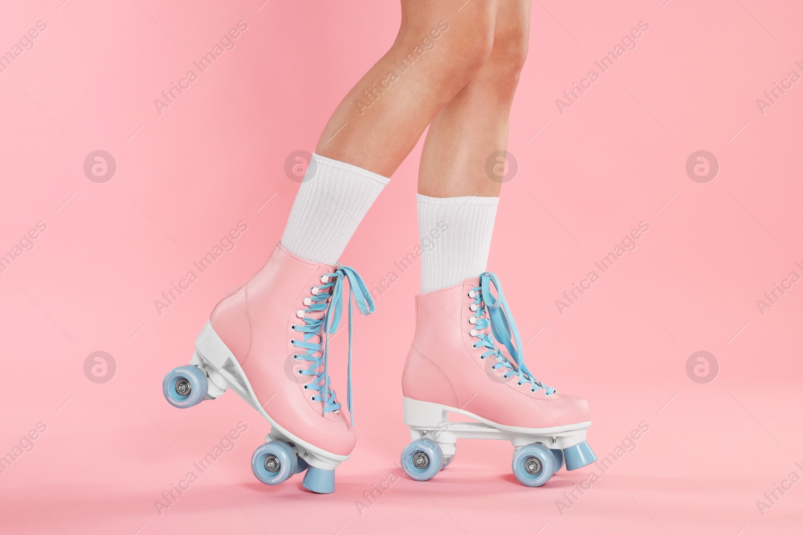 Woman in roller skates on pink background, closeup Photo of Woman in roller skates on pink background, closeup