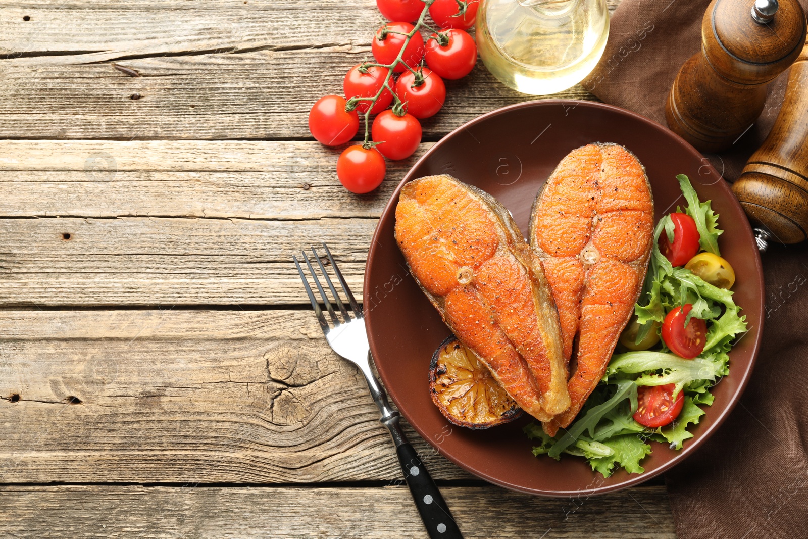 Seafood. Tasty salmon steaks served with salad and lemon on wooden table, flat lay. Space for text Photo of Seafood. Tasty salmon steaks served with salad and lemon on wooden table, flat lay. Space for text