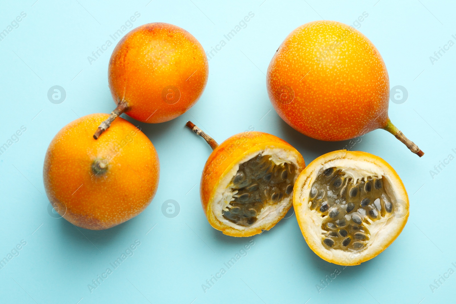 Ripe yellow passion fruits on light blue background, flat lay Photo of Ripe yellow passion fruits on light blue background, flat lay