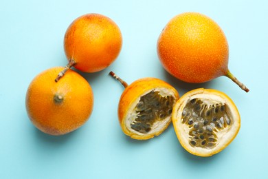 Photo of Ripe yellow passion fruits on light blue background, flat lay