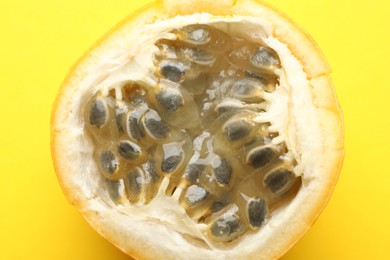 Photo of Piece of ripe passion fruit on yellow background, closeup