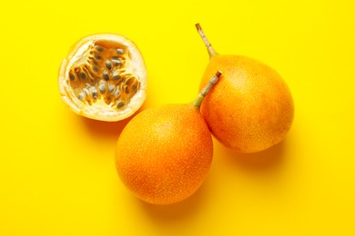 Photo of Ripe passion fruits on yellow background, flat lay