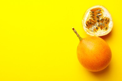 Photo of Ripe passion fruits on yellow background, flat lay. Space for text