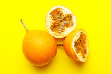 Photo of Ripe passion fruits on yellow background, flat lay