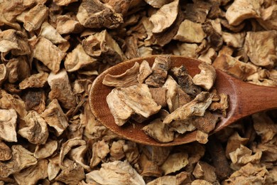 Photo of Pieces of dry chicory roots and spoon as background, closeup