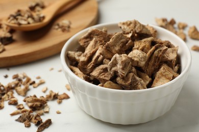 Photo of Pieces of dry chicory roots on white table, closeup