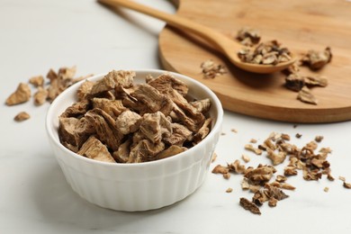 Photo of Pieces of dry chicory roots on white table, closeup