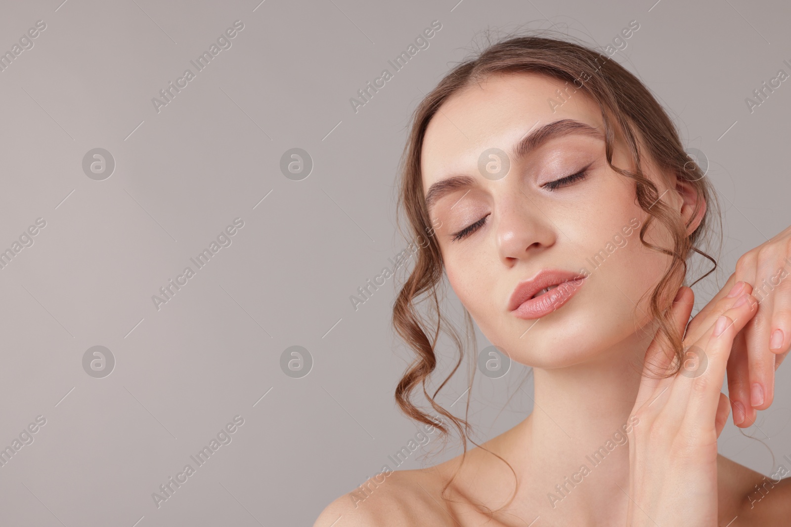 Portrait of attractive young woman on light grey background. Space for text Photo of Portrait of attractive young woman on light grey background. Space for text