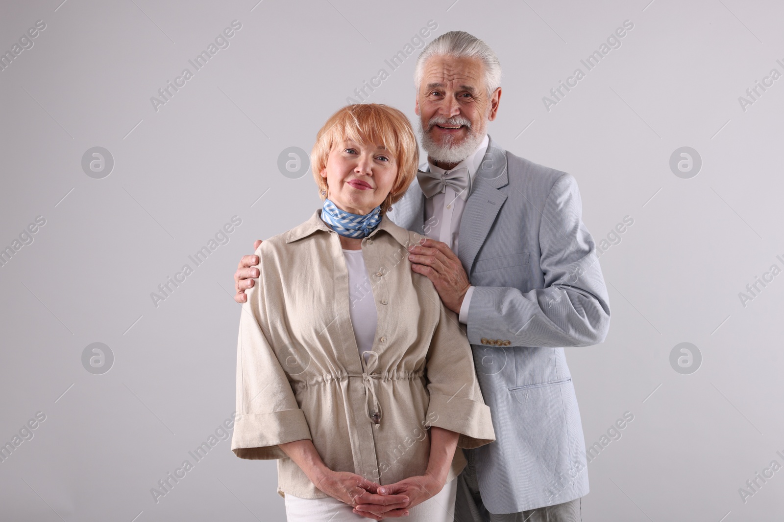 Lovely senior couple together on light grey background Photo of Lovely senior couple together on light grey background