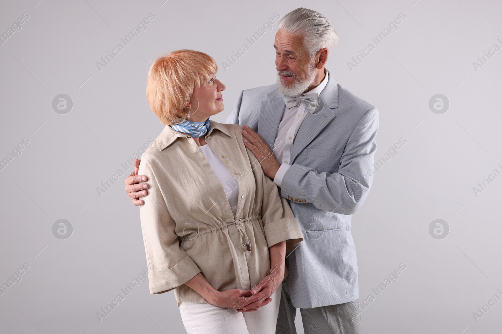 Lovely senior couple together on light grey background Photo of Lovely senior couple together on light grey background