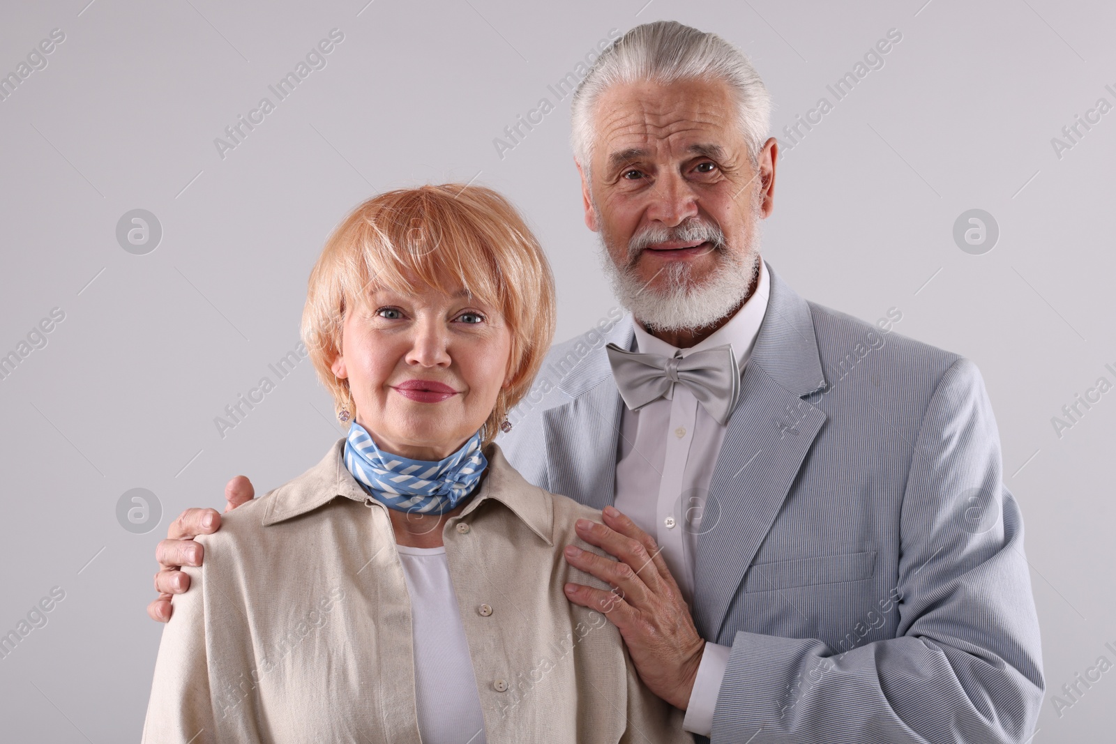 Lovely senior couple together on light grey background Photo of Lovely senior couple together on light grey background