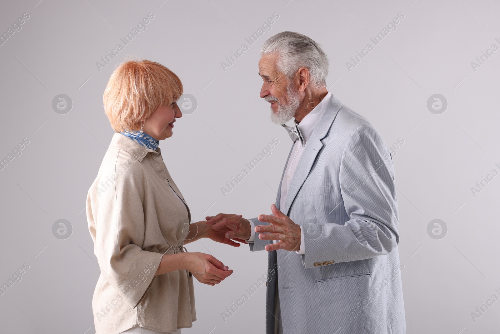 Lovely senior couple together on light grey background Photo of Lovely senior couple together on light grey background