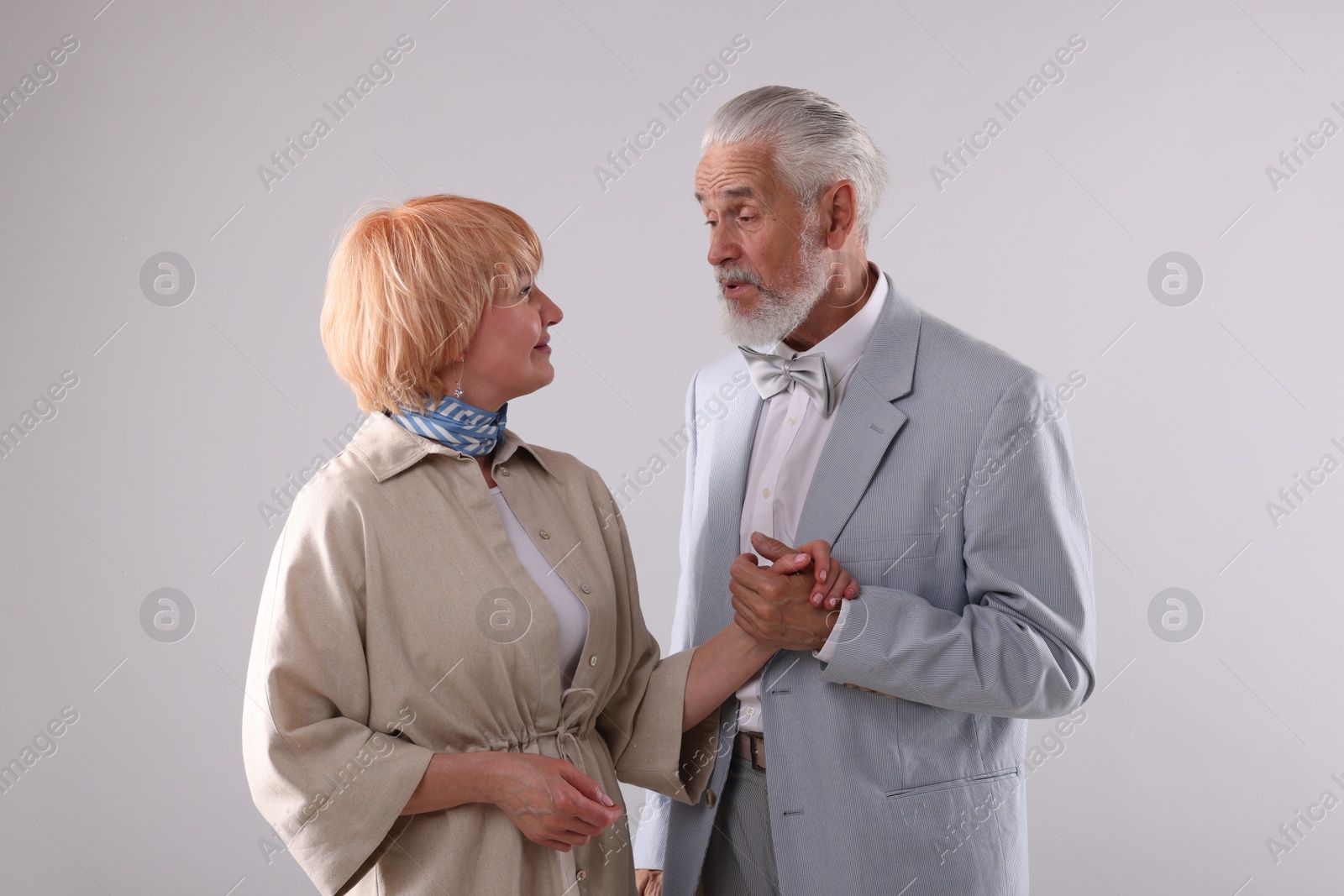 Lovely senior couple together on light grey background Photo of Lovely senior couple together on light grey background