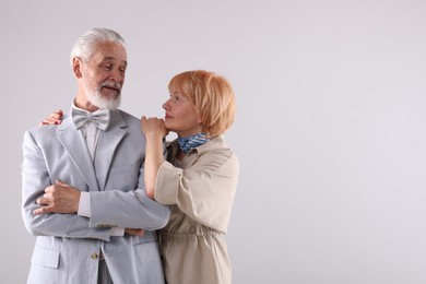 Photo of Lovely senior couple together on light grey background, space for text