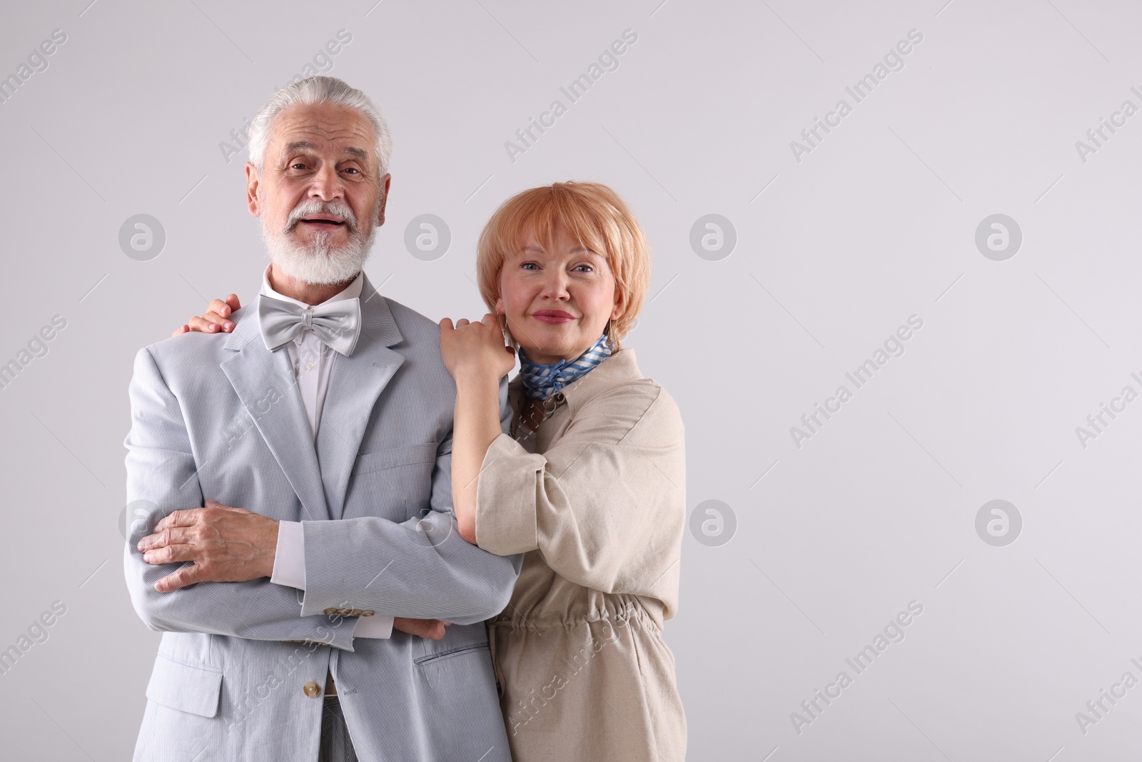 Lovely senior couple together on light grey background, space for text Photo of Lovely senior couple together on light grey background, space for text