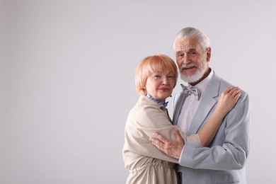 Photo of Lovely senior couple together on light grey background, space for text