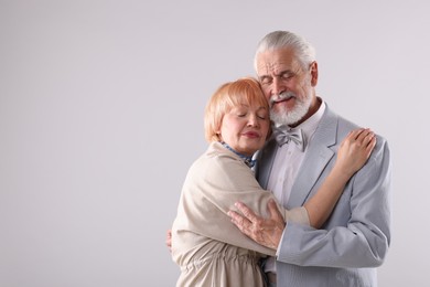 Photo of Lovely senior couple together on light grey background, space for text
