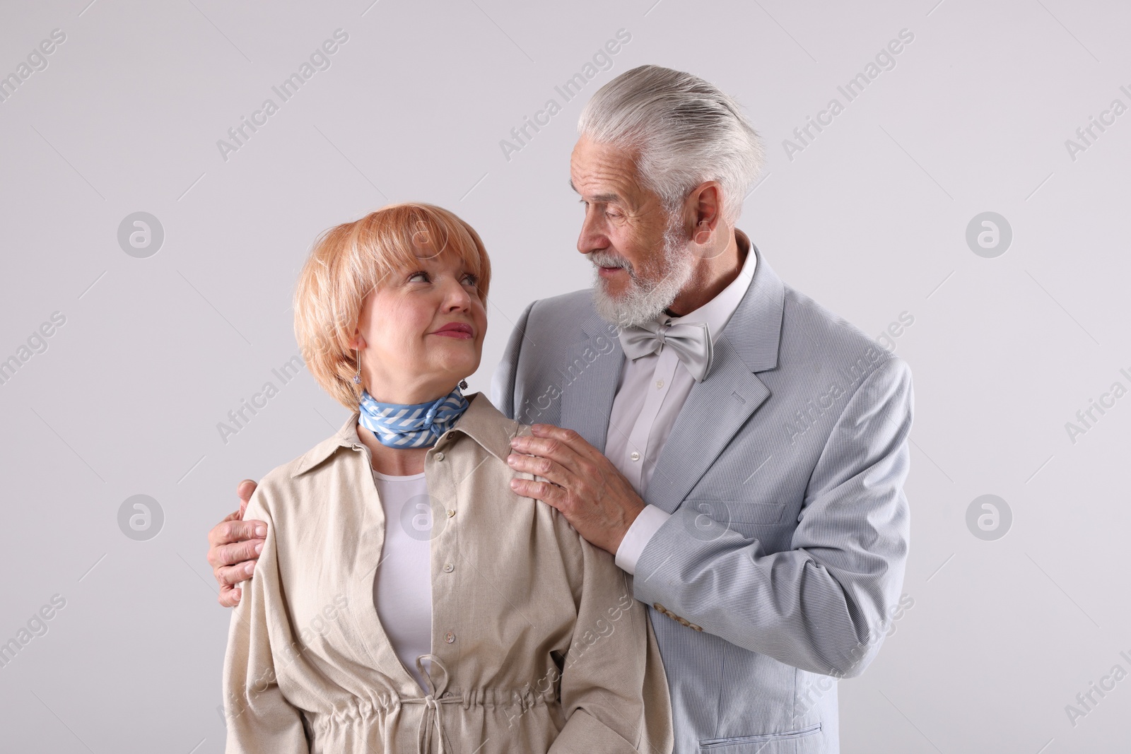 Lovely senior couple together on light grey background Photo of Lovely senior couple together on light grey background