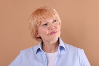 Photo of Portrait of senior woman on light brown background