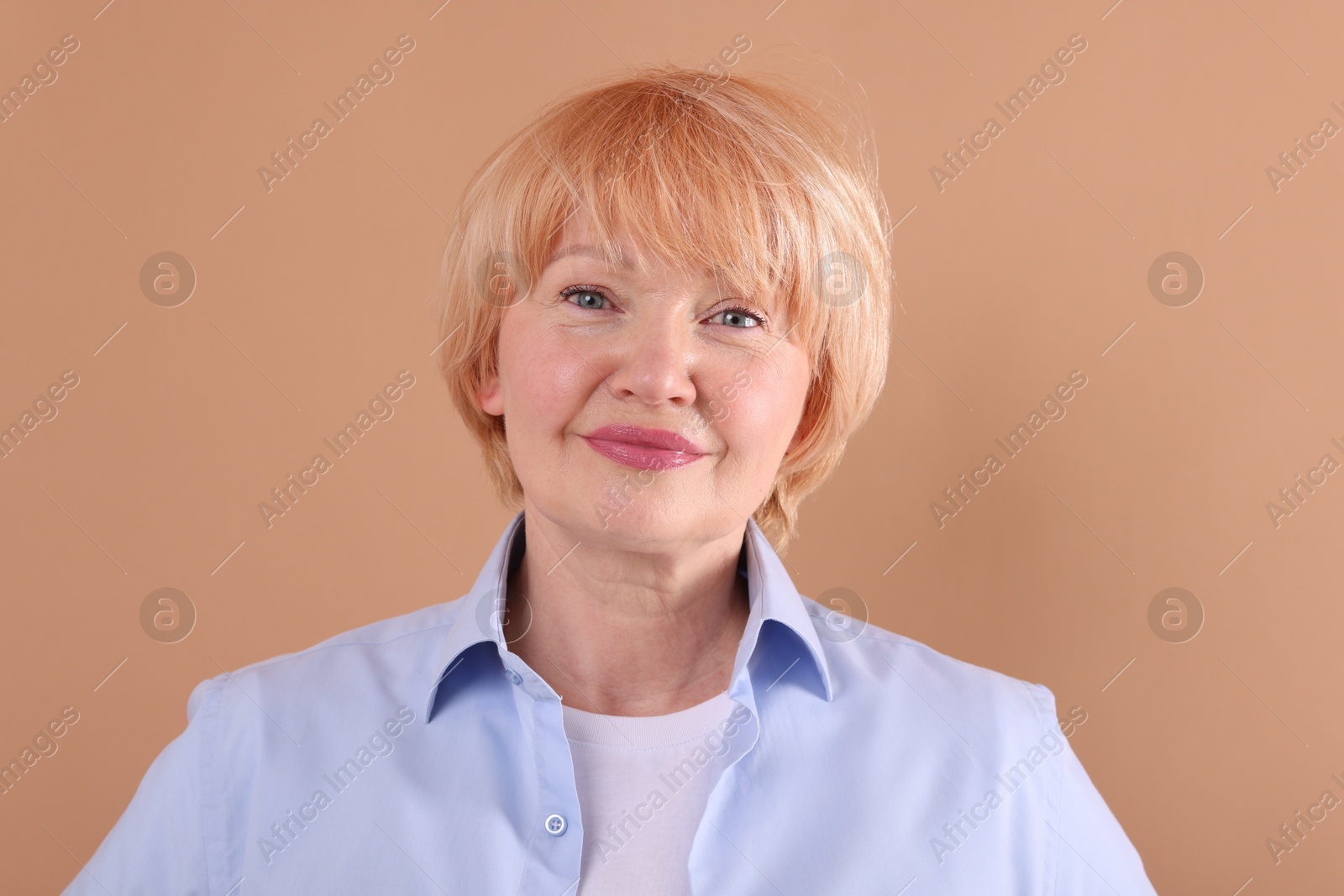 Portrait of senior woman on light brown background Photo of Portrait of senior woman on light brown background