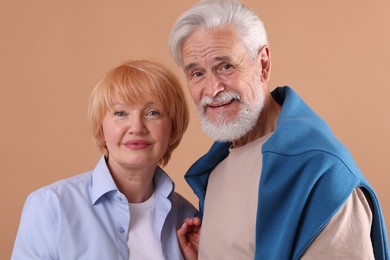 Photo of Lovely senior couple together on light brown background