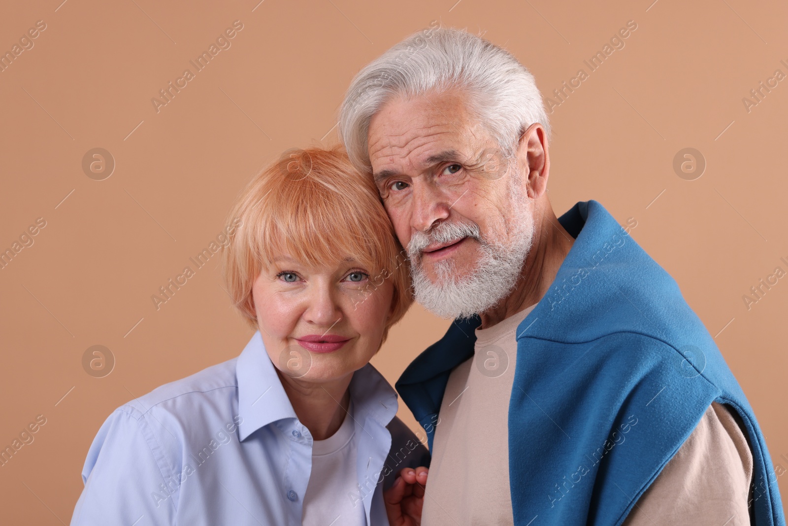 Lovely senior couple together on light brown background Photo of Lovely senior couple together on light brown background