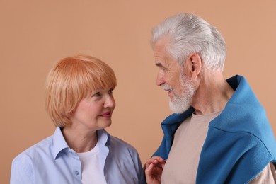 Photo of Lovely senior couple together on light brown background