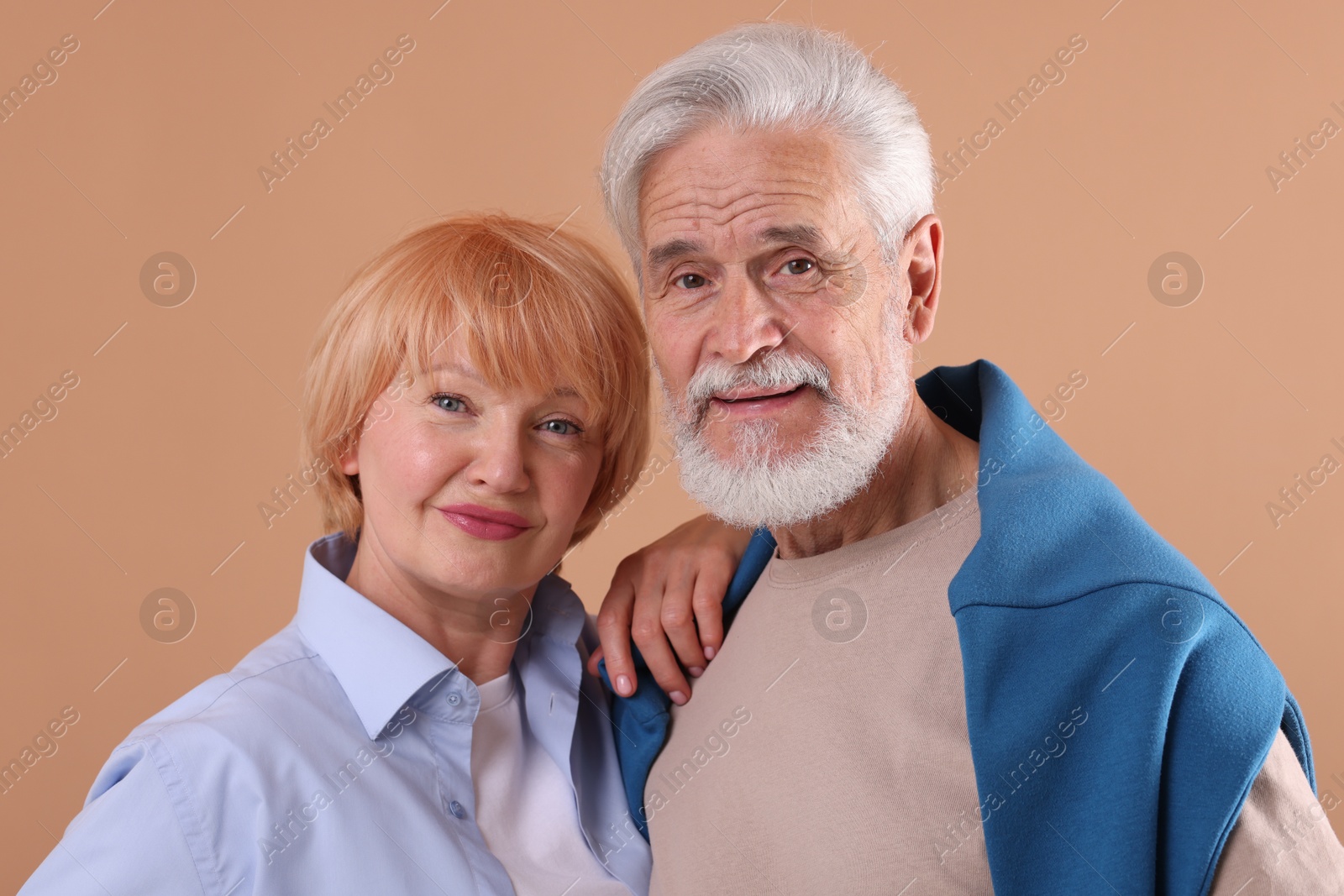 Lovely senior couple together on light brown background Photo of Lovely senior couple together on light brown background