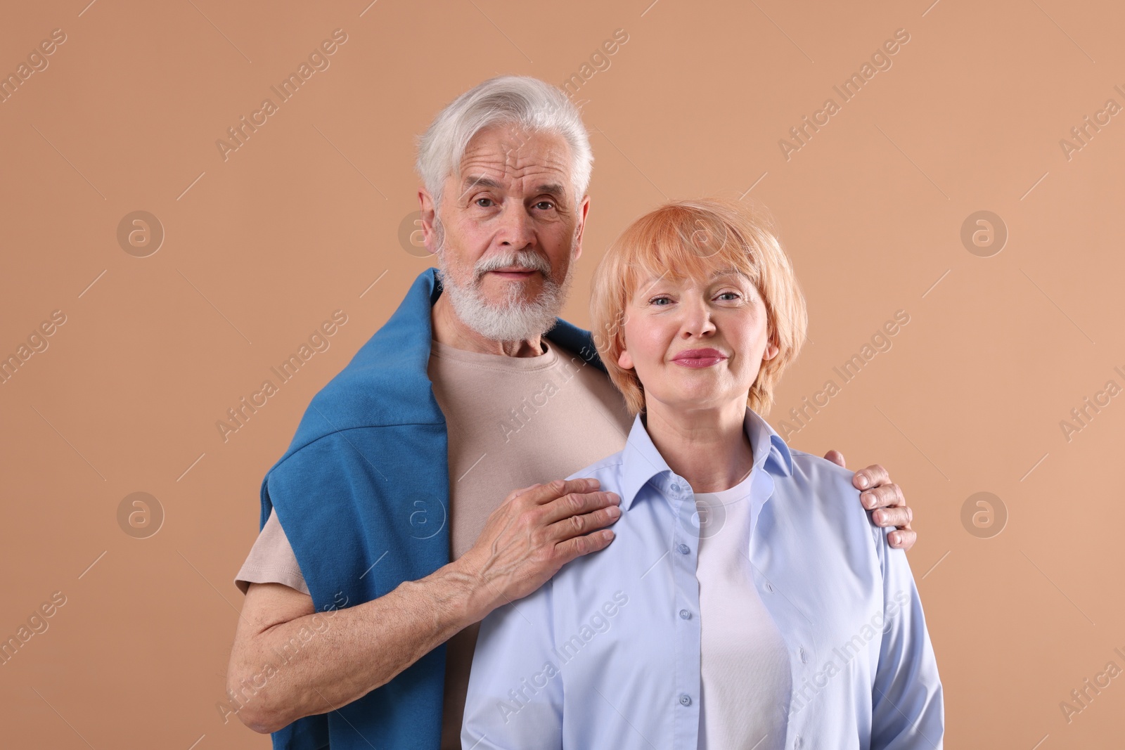 Lovely senior couple together on light brown background Photo of Lovely senior couple together on light brown background