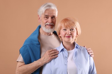 Photo of Lovely senior couple together on light brown background