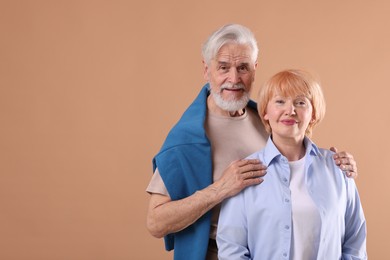 Photo of Lovely senior couple together on light brown background, space for text