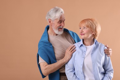Photo of Lovely senior couple together on light brown background, space for text