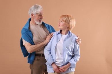 Photo of Lovely senior couple together on light brown background