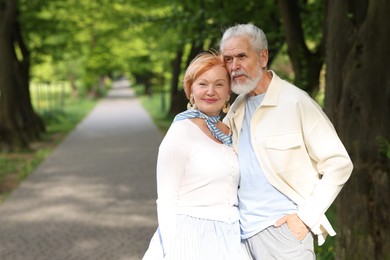 Photo of Lovely senior couple together in park, space for text