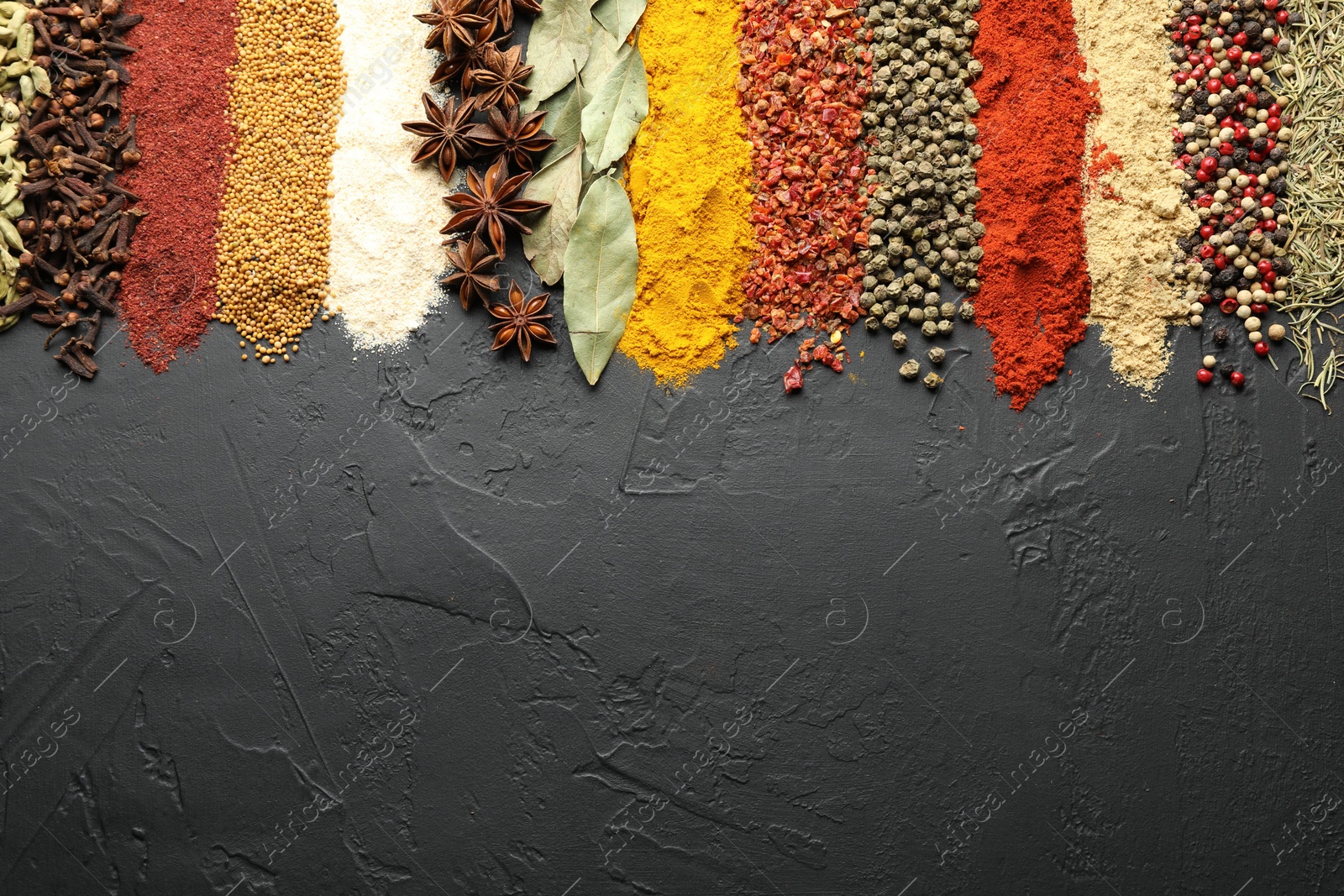 Many different spices on black table, flat lay. Space for text Photo of Many different spices on black table, flat lay. Space for text