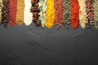 Photo of Many different spices on black table, flat lay. Space for text